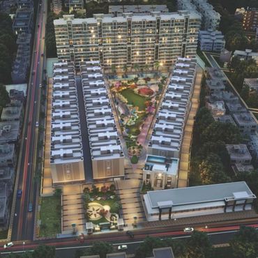 Aerial night view of a modern residential complex with illuminated pathways and green spaces.