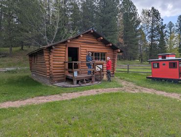 two people standing in front of log cabin