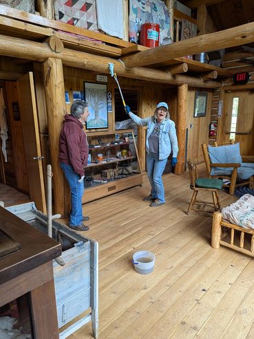 two women cleaning log beams