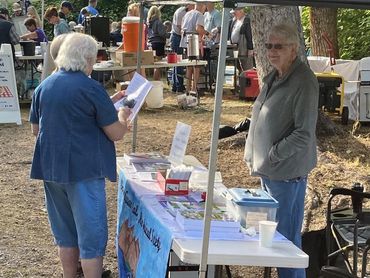 women setting up USVHS display table