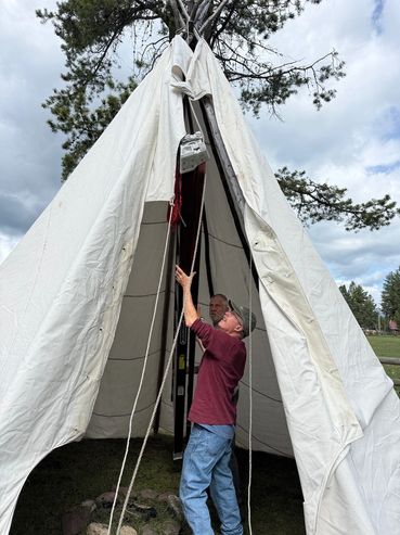 people setting up a tipi