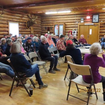 group of people, seating in log building room