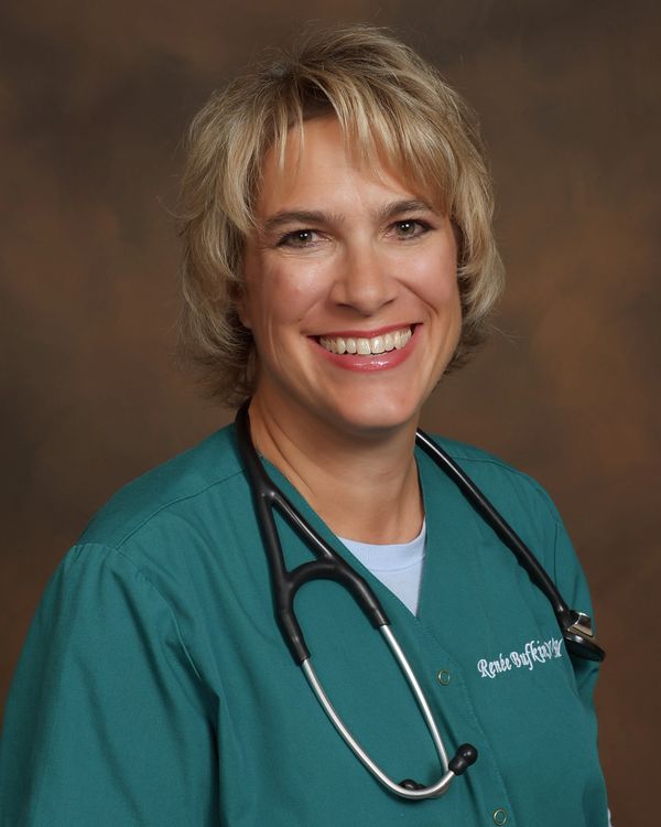 Smiling female healthcare professional in teal scrubs with a stethoscope.