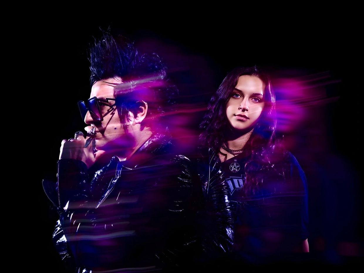 Two individuals with edgy styles and purple light effects against a black background.