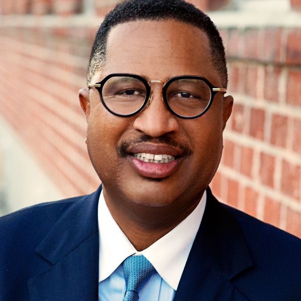 Smiling man wearing glasses and a suit.