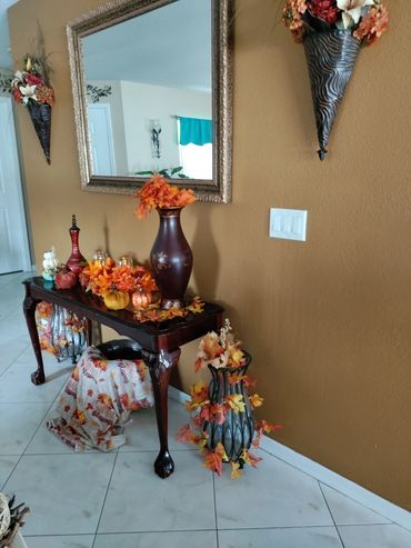 Fall harvest decorated table against colored accent wall.  Sofa table is decorated with tall brown v