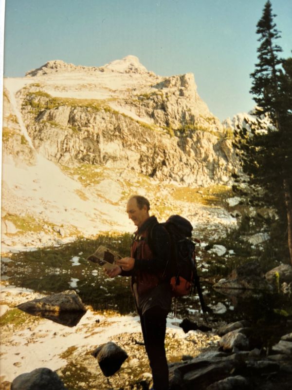 Man mountaineering with map and compass on a mountain adventure