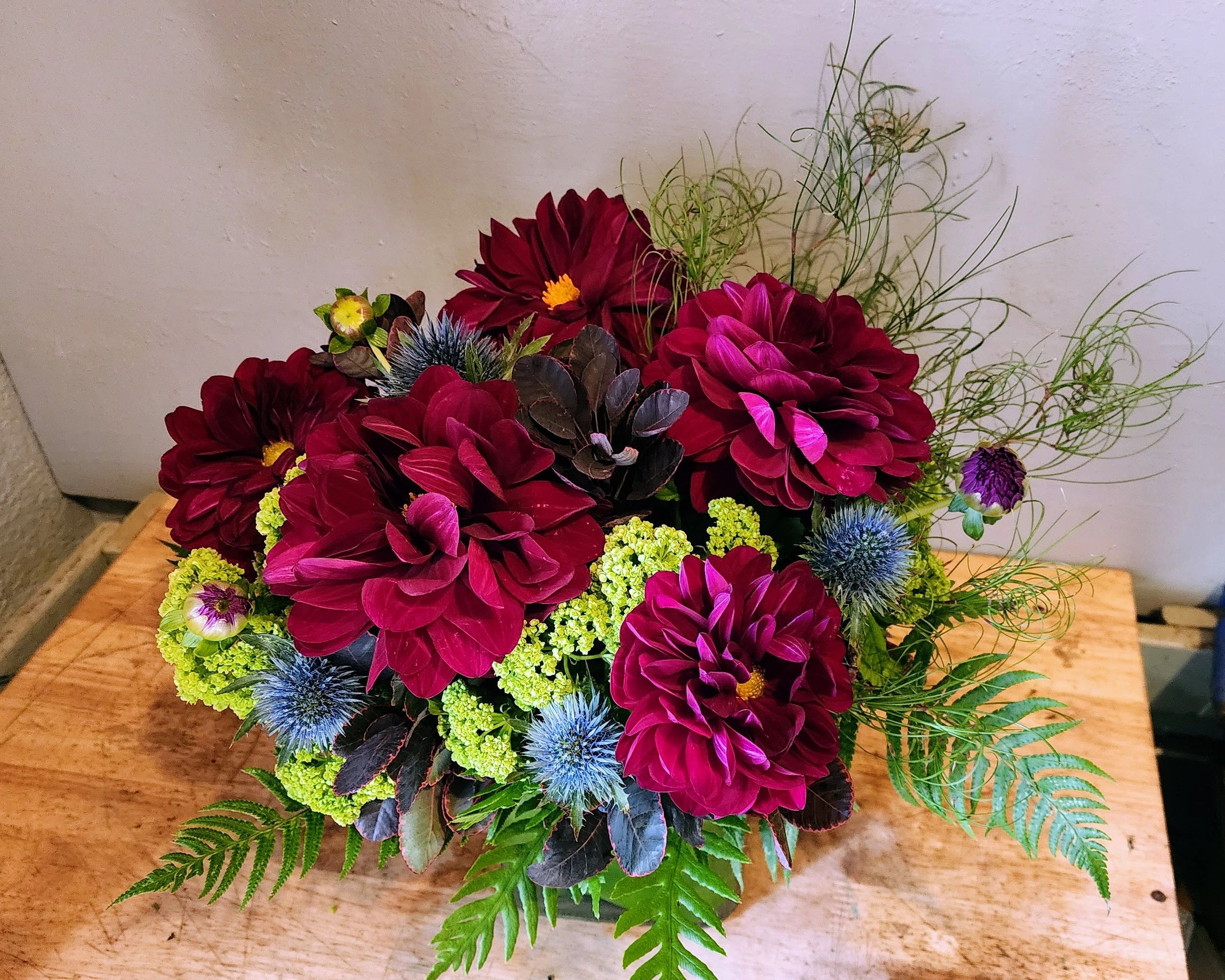 Erebus' Enchanted Twilight, floral arrangement, burgundy dahlias, viburnum, alpine thistle and fern.