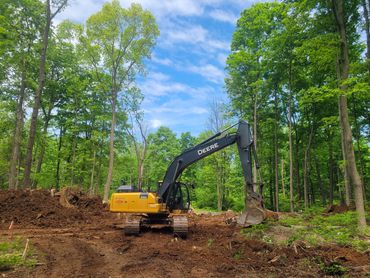 70,000 lbs excavator site clearing, striping topsoil, rock lot.