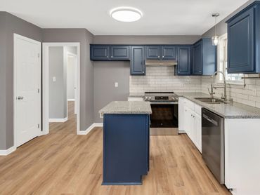 Modern kitchen with blue cabinets and wood flooring. Fastest way to sell your house fast