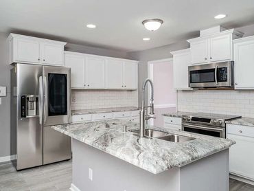 Modern kitchen remodel with white cabinets and marble countertops. Sell your house today.