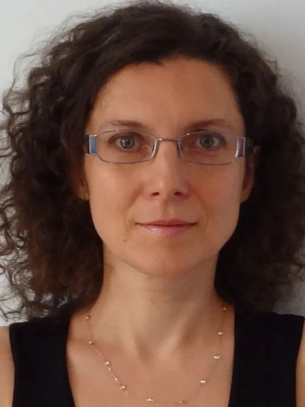 Woman with curly hair and glasses.