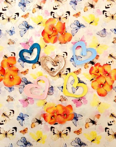 Colorful heart shapes and orange flowers on butterfly-patterned fabric.