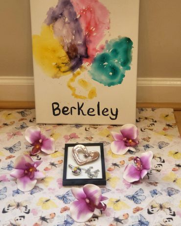 Colorful Berkeley painting with heart-shaped pendant and purple flowers on butterfly fabric.