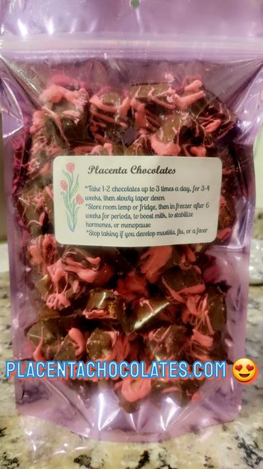 A bag of placenta chocolates with pink drizzle and usage instructions on the label.
