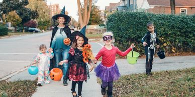 Mom taking kids trick or treating.