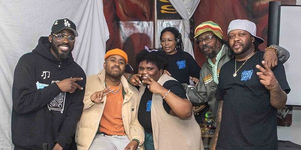Group of six people posing indoors, some making peace signs.