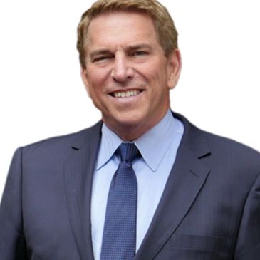 Confident man in a suit smiling against a white background.