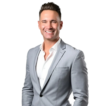 Smiling man in a light gray suit with hands in pockets.