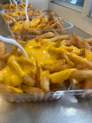 Alt=Four separate orders of cheese fries at MooSa's"