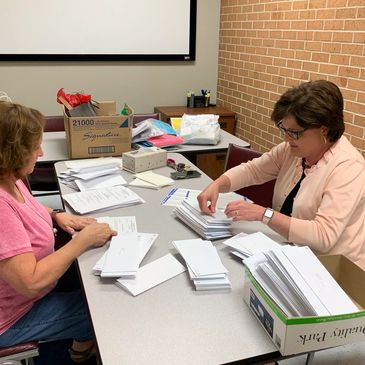 A woman preparing envelopes to the invites