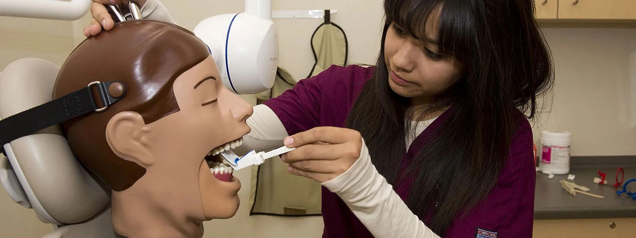 Dental Assistant training on manaquine head practicing inserting xray film