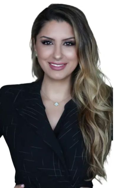Confident woman with long wavy hair smiles warmly in a black outfit.