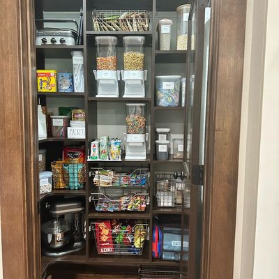 Custom pantry shelving with wire baskets and open food storage.