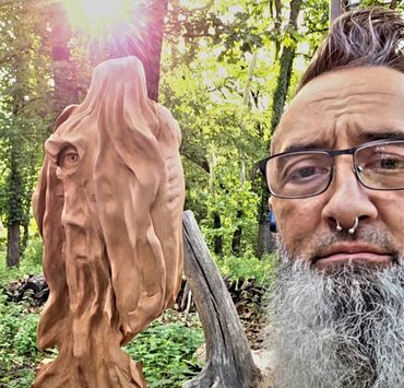 Artist Chad Rev posing with a work in progress with the sun glaring in background