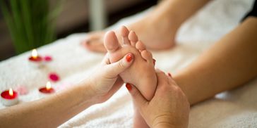 Reflexology foot massage uses pressure points on the feet to relax the body and mind.