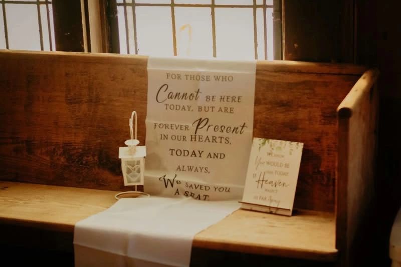 Memorial setup on a wooden bench with a heartfelt message and lantern.