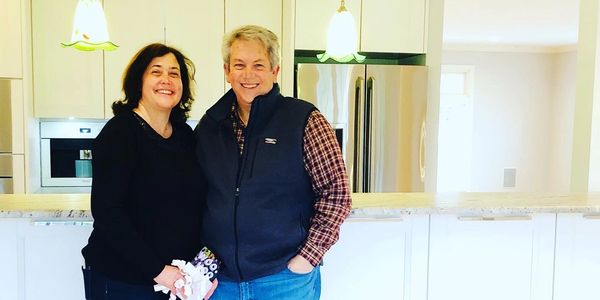 Couple who bought and sold proudly standing in the kitchen of their stunning new home.