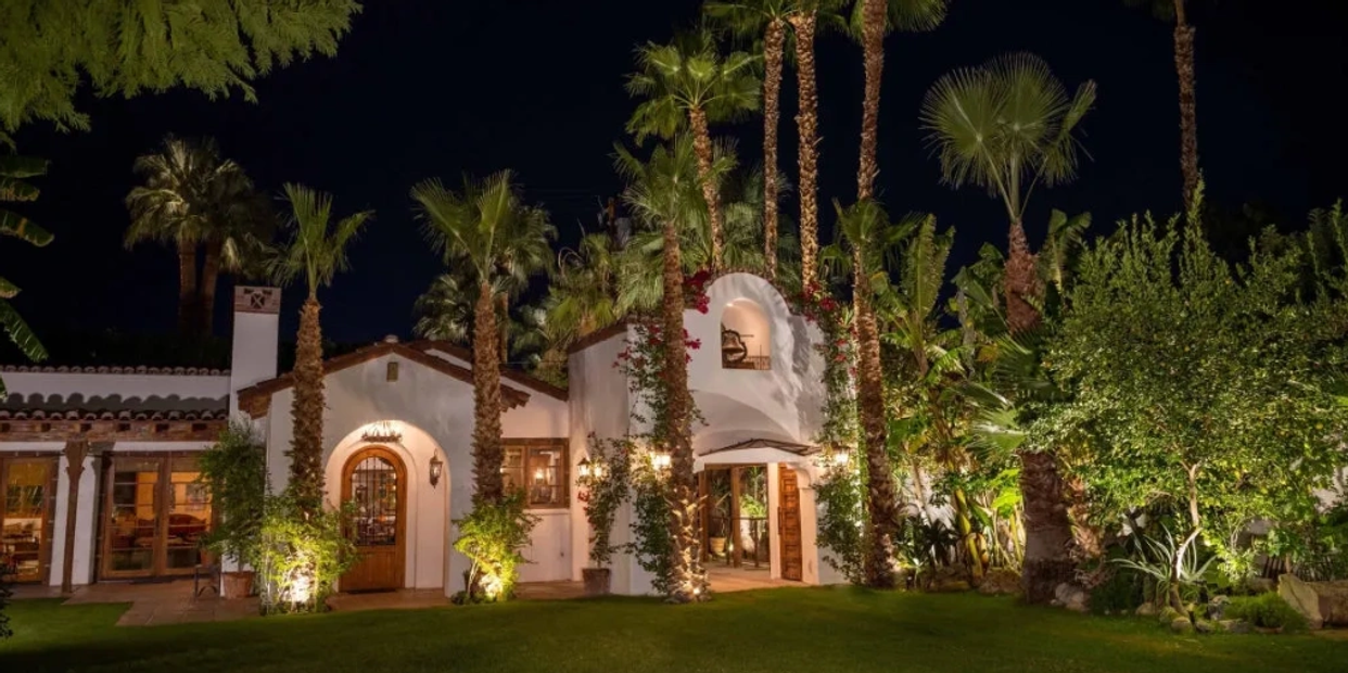 Spanish revival estate at night with palm trees