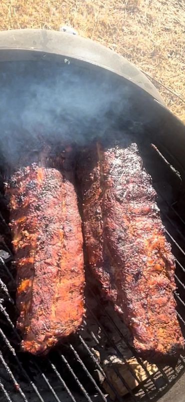 Two glazed and charred slabs of St. Louis Style Ribs, smoked then barbecued.