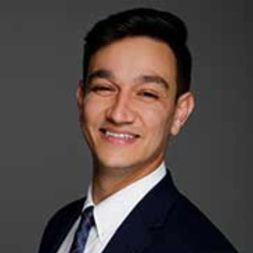 Professional headshot of a smiling man in a suit.