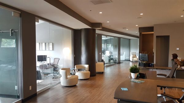 Modern office space with glass partitions and seating.