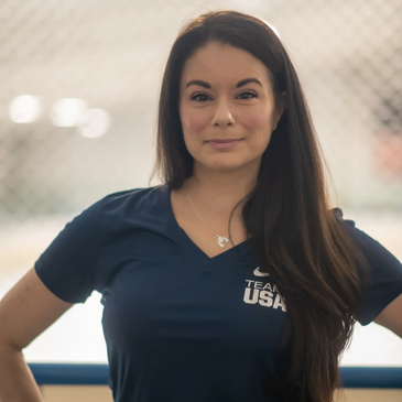 Confident woman wearing a Team USA shirt with long dark hair.
