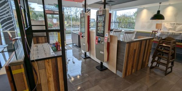 Modern fast food restaurant interior with self-service kiosks.