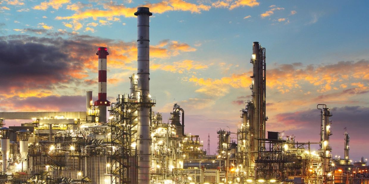 Industrial refinery complex with sunset sky.