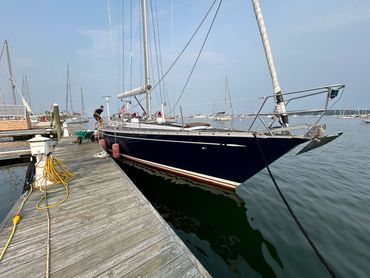 A sailboat docked at a marina on a calm day.