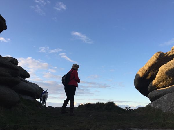 walker with dog on rocks