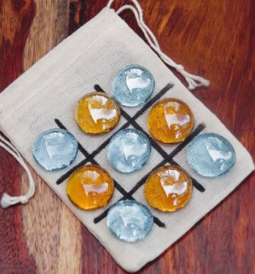Tic-tac-toe game with glass stones on a cloth bag.