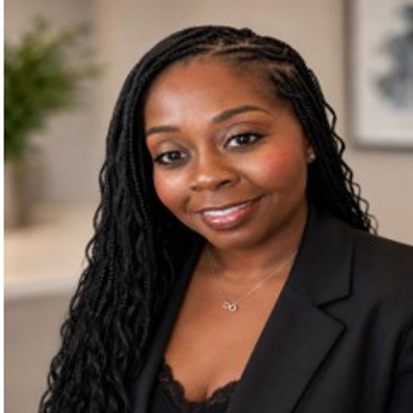 Smiling woman with braided hair in black blazer.