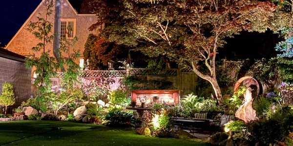 Backyard garden at night lit up by landscape lighting