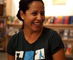 Milta wearing a WritesCorps t-shirt with a big hearty smile. 