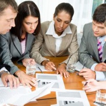 Four professionals engaged in a focused business meeting around a table.