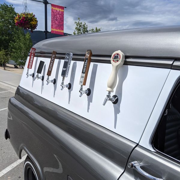 Beer taps installed on the side of a vintage gray vehicle.