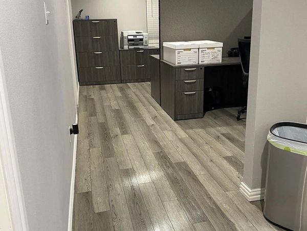 Modern office space with wooden flooring and organized desks.
