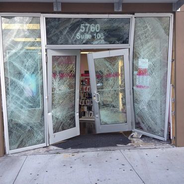 T-Mobile store entrance with shattered glass doors and windows.