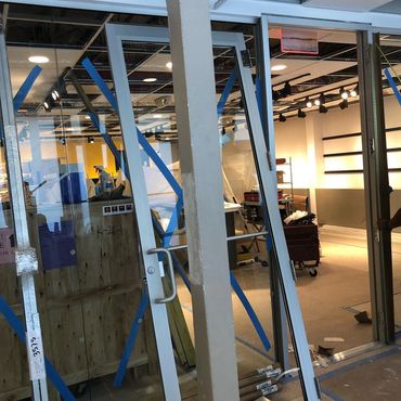 Glass doors being installed in an indoor construction site.